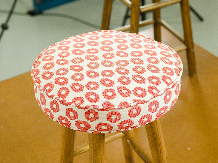 Finished bar stool with fabric top.